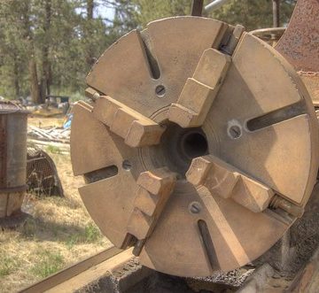 18-inch 4-jaw chuck / faceplate of a ventury-old 20-inch x 12-foot Muller metal lathe in a junkyard, made by the Bradford Mill Company