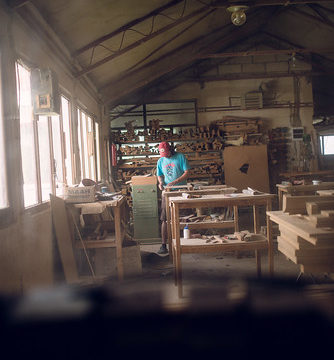 A young man working alone in a furniture workshop