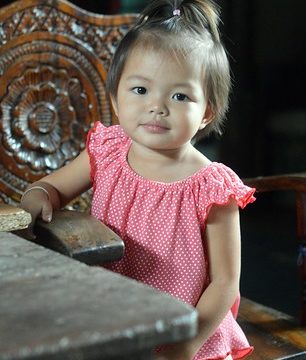 cute toddler in a carved wooden chair