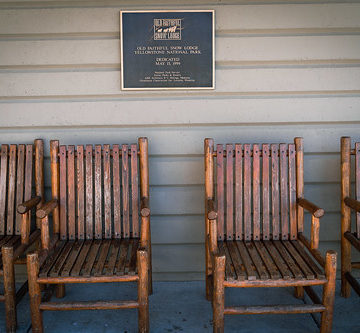 Wyoming, USA - July 18, 2022: Dedication plaque for the Old Faithful Snow Lodge hotel, with wooden chairs outside